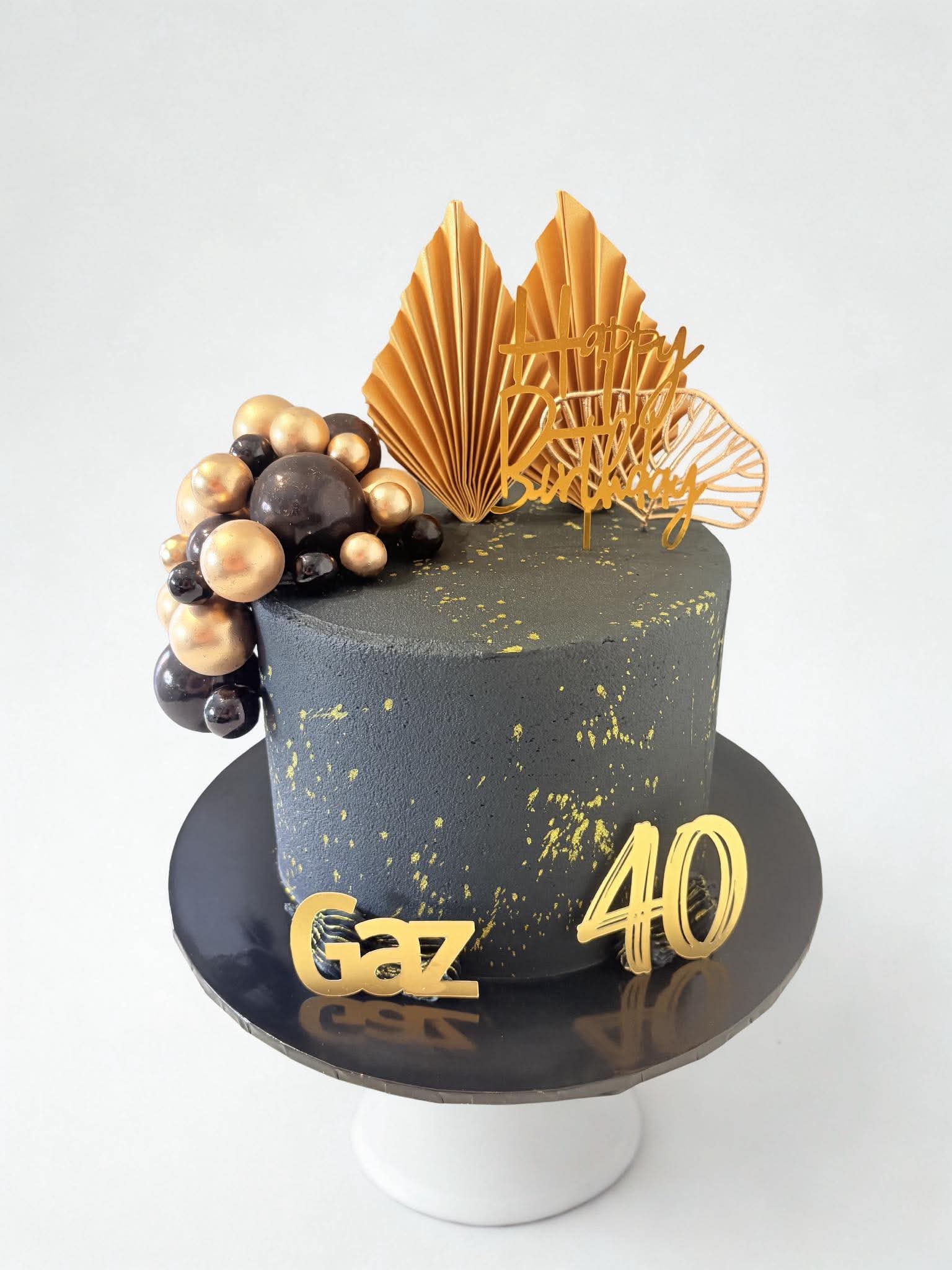 Black and gold 40th birthday cake with gold fans and chocolate spheres