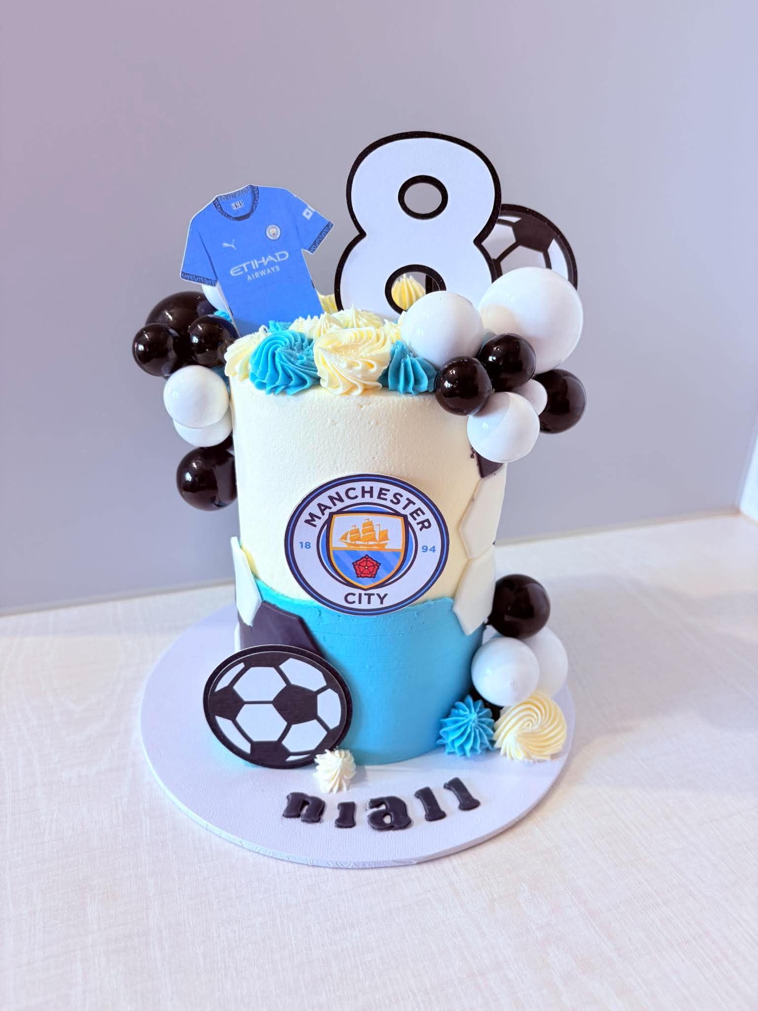 Manchester City football birthday cake with blue, black and white decorations
