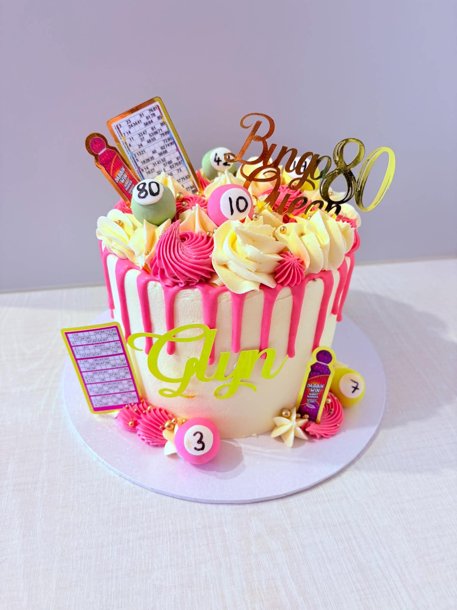 Pink bingo themed 80th birthday cake with game card decorations
