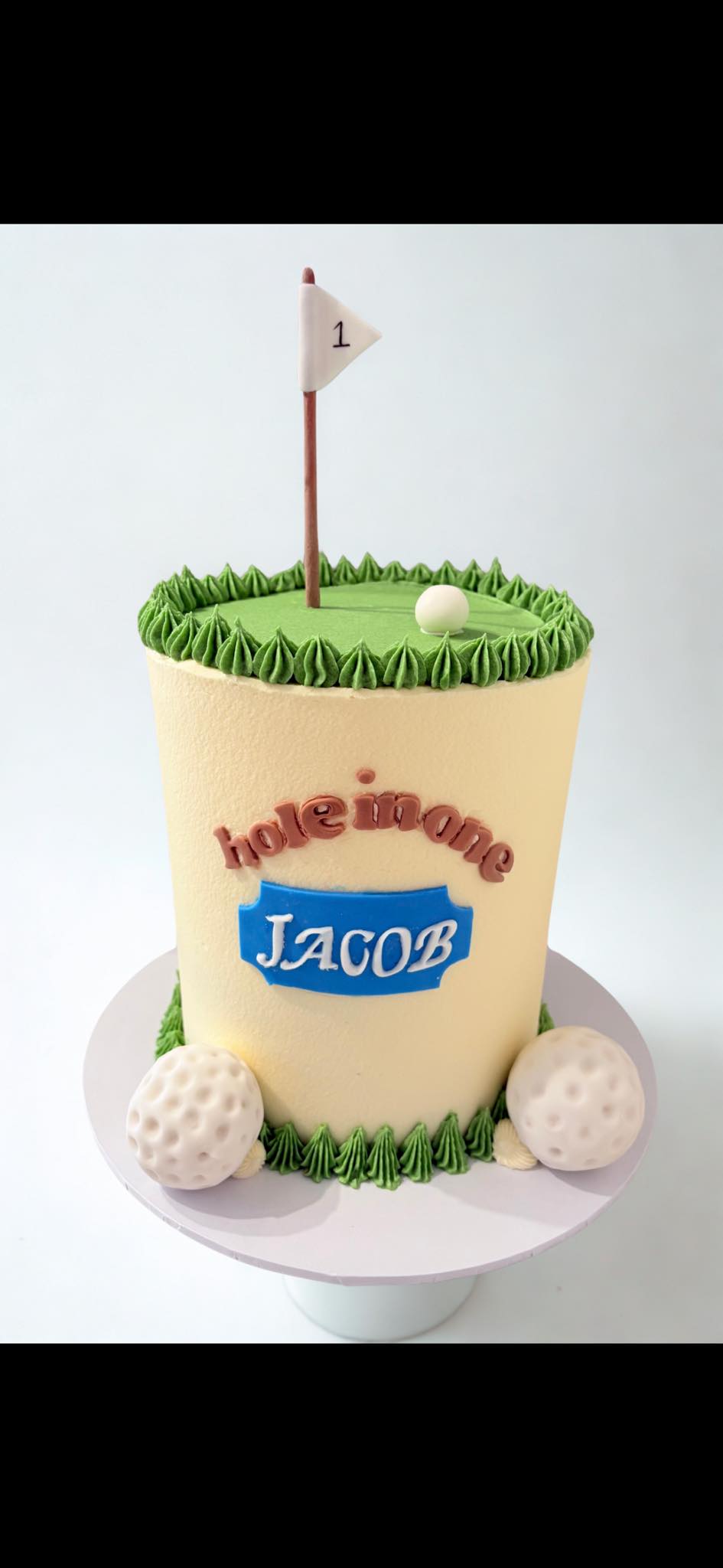 Golf-themed first birthday cake with a flag and golf balls