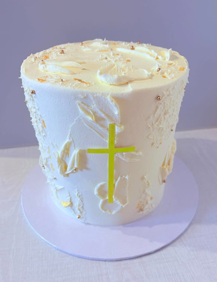 Ivory christening cake with gold details and a yellow cross